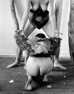 Feminism and the Legacy of Surrealism - Betsy Damon, <i>Body Masks (no. 3)</i>, 1976/2021. Black & white photograph, 24 x 36 in. Edition 1 of 6 (+2 AP). Courtesy of the artist and Monika Fabijanska Contemporary Art Projects.
<br>
<br>
Betsy Damon’s <i>Body Masks</i> is a series of photographs from a 1976 performative session in the artist studio in New York City. Damon (b. 1940) started doing performance with the Feminist Art Studio, which she founded at Cornell University in 1972. Raised with an intimate relationship to nature, in Ithaca, set among hills, woods and waterfalls, Damon began exploring her female body as a powerful creative force. This connection with nature permeated both her feminist rituals organized with other women in the open, and wood sculptures that she created at the time. In 1976 Damon leaves Ithaca and joins the lesbian artist community in New York City. Materials such as feathers and palm tree bark enter the studio with her. <i>Body Masks</i> both conceal and reveal, shielding the artist while she creates and confronts her new self and new life – vulnerable, sexual, and preparing to step into public space. They presage Damon’s performance career which will begin a year later, which will be marked by a close collaboration with other women and her intimate relationship with nature – raw power of the female body and nature’s constant rebirth.
<br>
<br>
— Text by Monika Fabijanska