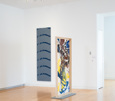 Installation view of 52 Artists: A Feminist Milestone; left: Dona Nelson, “Untitled” (1968), acrylic on canvas, 95 inches x 29 inches; right: “Federal Yellow” (2019), acrylic on canvas, 81 inches x 36 inches (photo by Jason Mandella, courtesy the Aldrich Contemporary Art Museum, Ridgefield, CT)