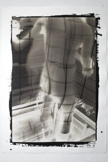 Opal Ecker DeRuvo, <i>Projection II</i>, 2021. Kallitype, palladium toned. 41 x 29.5 in. Edition of 5 (+1 AP).
<br>
<br>
Opal Ecker DeRuvo is a nonbinary artist working with the materials, processes, and histories of photography. In the project presented in "Unfurled", DeRuvo projects laser beams in an evenly spaced grid structure unto their transfeminine body. 

Historically, grids were often used as backdrops in ethnographic photography or portraits as a method for assessing "types" or ethnic characteristics (a methodology not dissimilar to the use of digital datapoints in today's facial recognition technology). In projecting the laser generated structure onto the contours of their own body, DeRuvo upsets scientific "rationality", allowing for fluid representations of the self. They further obscure the "straight" reading of their likeness with the use of double exposures and additional light sources. 

DeRuvo uses historic photo-processes, such as kallitype, and sometimes transfers large-scale images onto architectural substrates like sheetrock (e.g. in the works “Gaze” and “Mechanical Reproduction”) connecting the materiality of photography with experiences of trans-embodiment.
